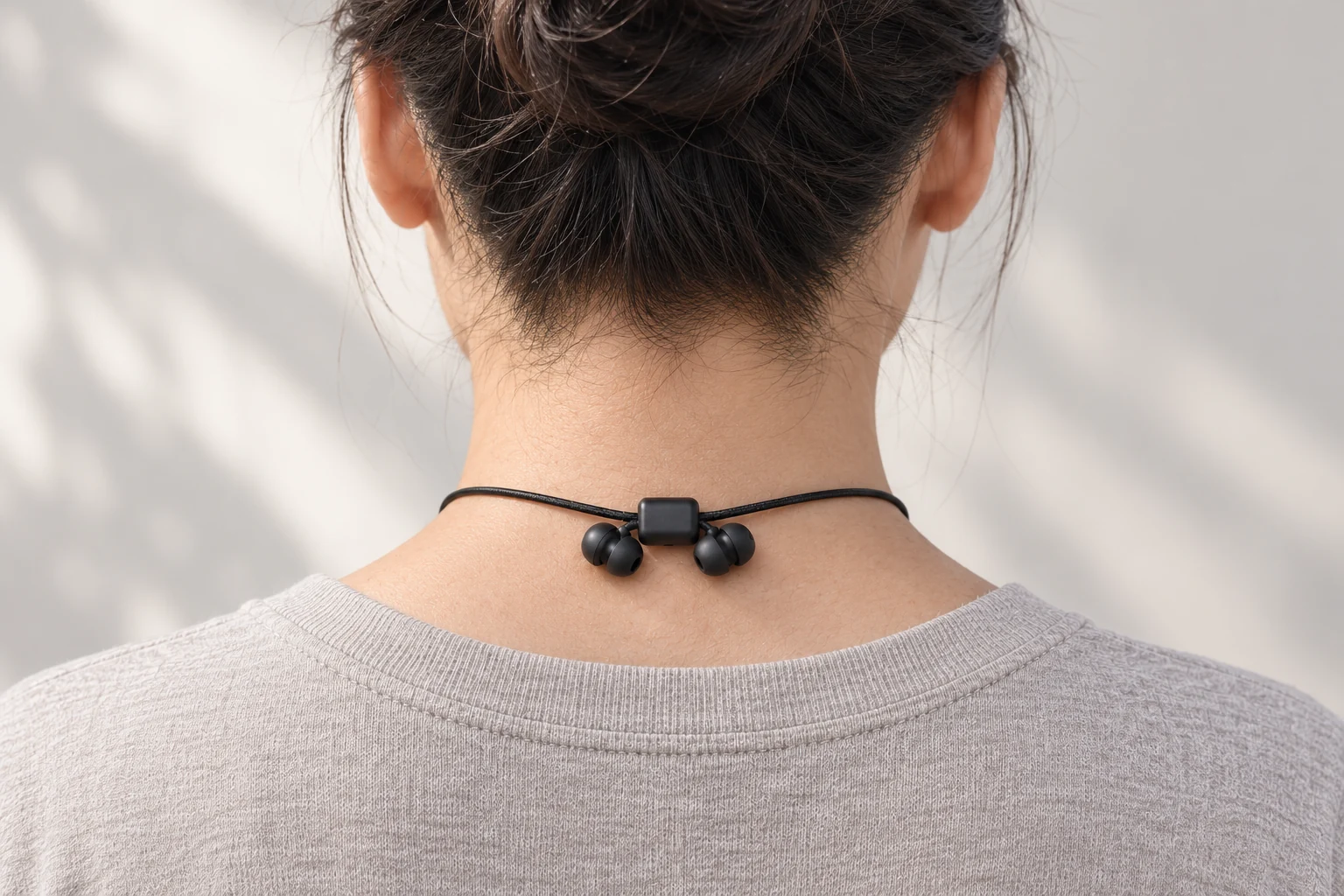 Pre-production visualization of the rear-neck slider with two separate earbuds gathered nearby